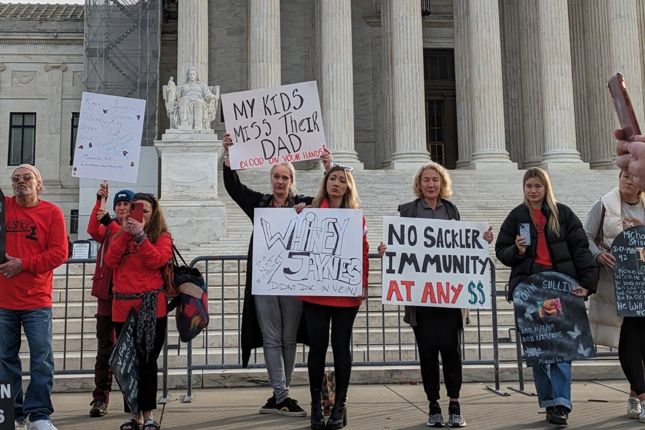 People protest with handmade signs outside the Supreme Court